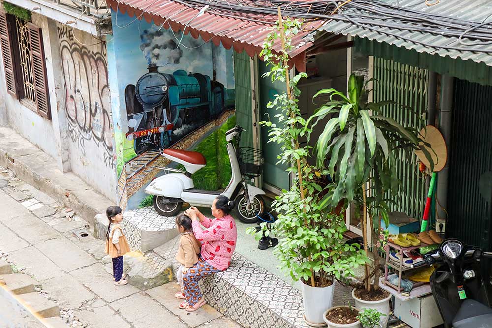 People doing their daily chores in the Hanoi Trains Street Slums