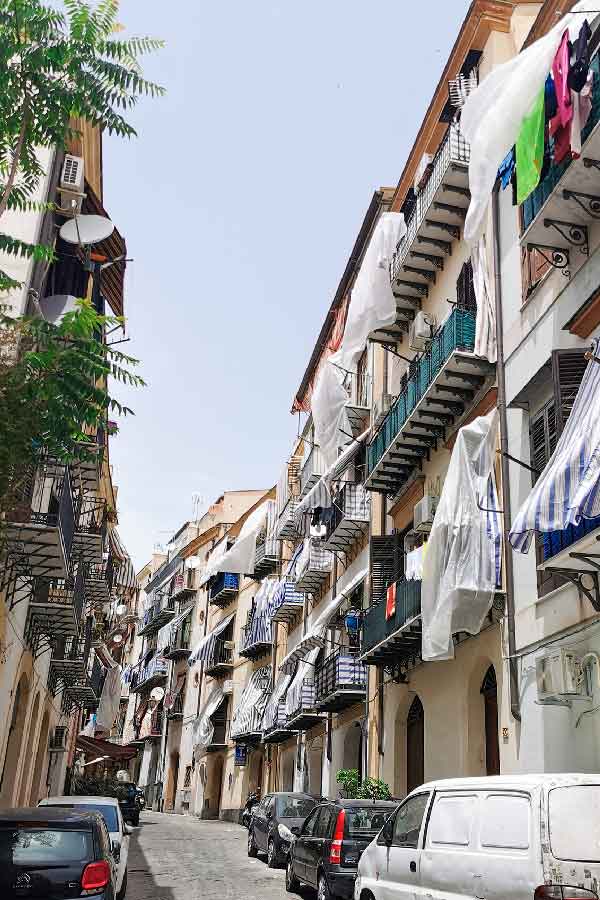 Houses with tiny windows and curtains blown by the wind in the Old Center streets of Palermo, Sicily, Italy